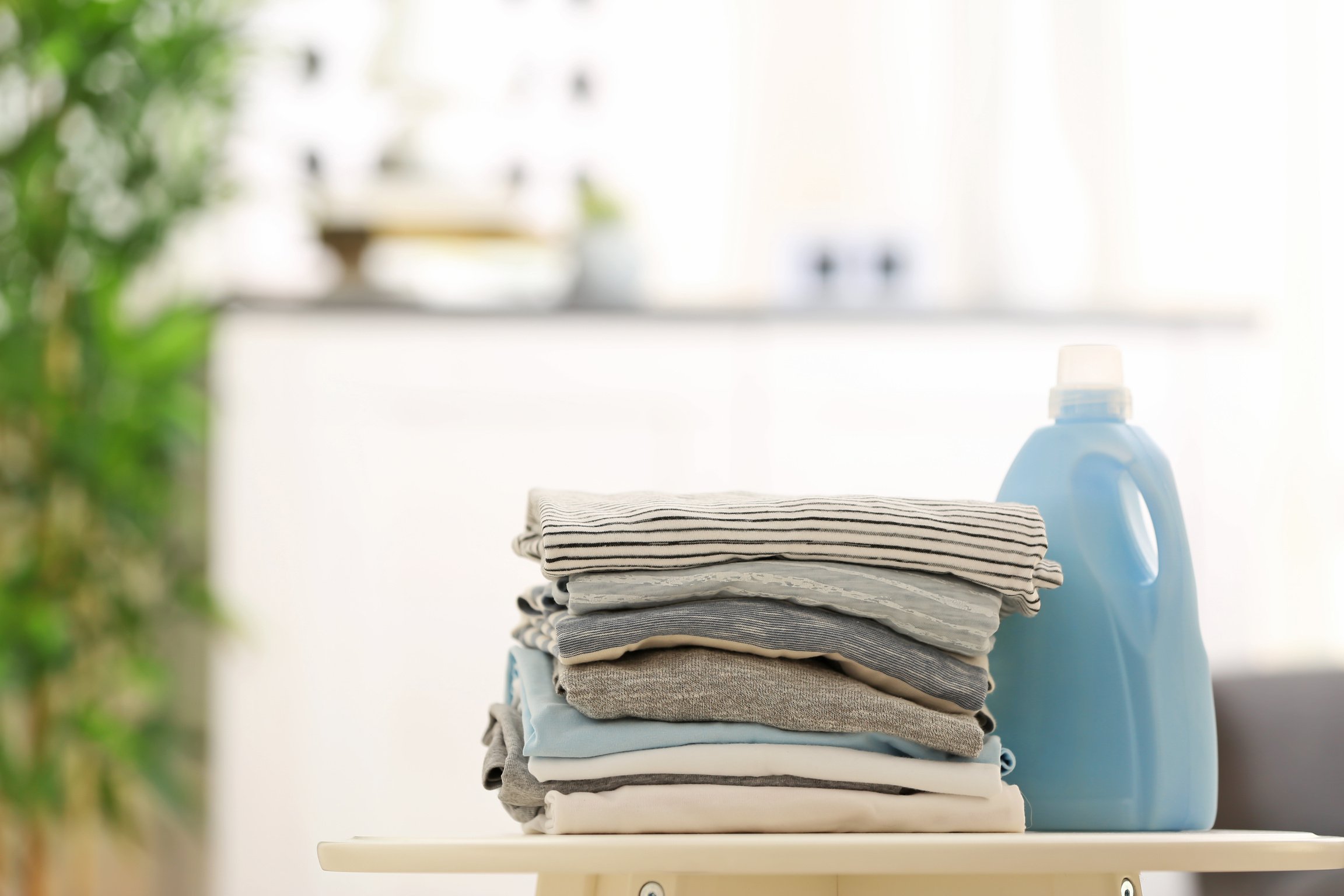 Stack of Clothes and Laundry Detergent in Laundry Room